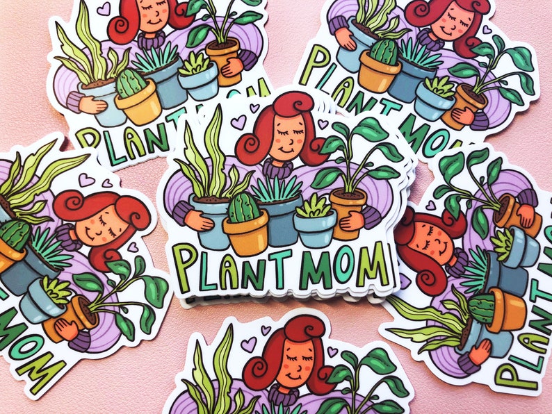 May include: A set of colorful stickers featuring a cartoon woman with red hair holding various potted plants. The stickers say "Plant Mom" in a whimsical font.