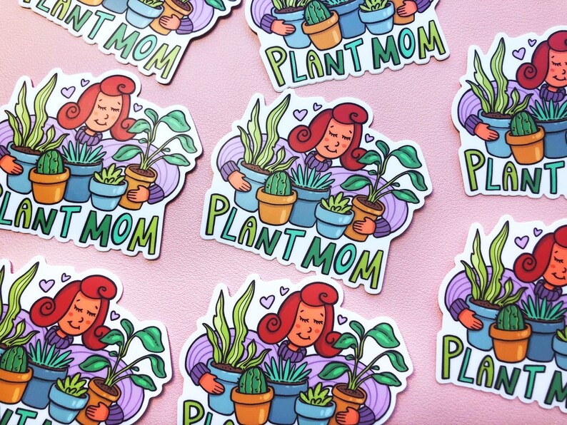 May include: A set of colorful stickers featuring a cartoon woman with red hair holding various potted plants. The stickers say "Plant Mom" in a whimsical font.
