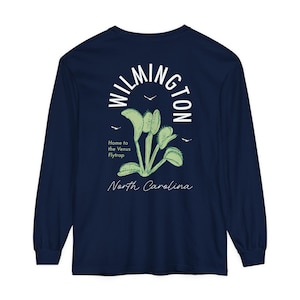 May include: Navy blue long-sleeve t-shirt with a white graphic of a Venus flytrap plant and the text "WILMINGTON Home to the Venus Flytrap North Carolina".