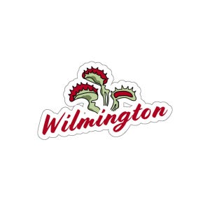 Puede incluir: Una pegatina con una ilustración estilizada de una planta carnívora Venus atrapamoscas, en verde y rojo. La palabra "Wilmington" está escrita en rojo en cursiva, con un contorno blanco.