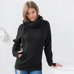 May include: Black hooded sweatshirt with a cowl neck and front pocket. The sweatshirt has drawstrings with metal tips and thumbholes. The model is wearing blue jeans.