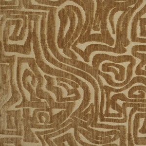 May include: A close-up of a fabric with a brown and beige abstract pattern. The pattern is made up of swirling lines and shapes.