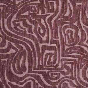 Puede incluir: Primer plano de una tela con un patrón abstracto rosa y marrón. El patrón está formado por líneas onduladas y círculos.