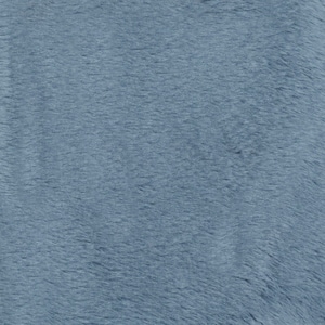 Puede incluir: Primer plano de una tela suave, azul y peluda. La tela tiene una textura sutil y una apariencia ligeramente descolorida.