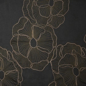 May include: A dark gray fabric with a repeating pattern of beige embroidered flowers. The flowers have a delicate, intricate design.