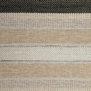 May include: Close-up of a woven fabric with a striped pattern in shades of beige and brown. The fabric has a textured surface and a subtle herringbone pattern.
