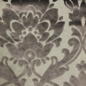 Pu&ograve; includere: Un tessuto con un motivo damascato in velluto grigio scuro su uno sfondo beige chiaro con una sottile trama a coste diagonali. Il design in velluto &egrave; composto da grandi motivi floreali e foglie simmetriche.