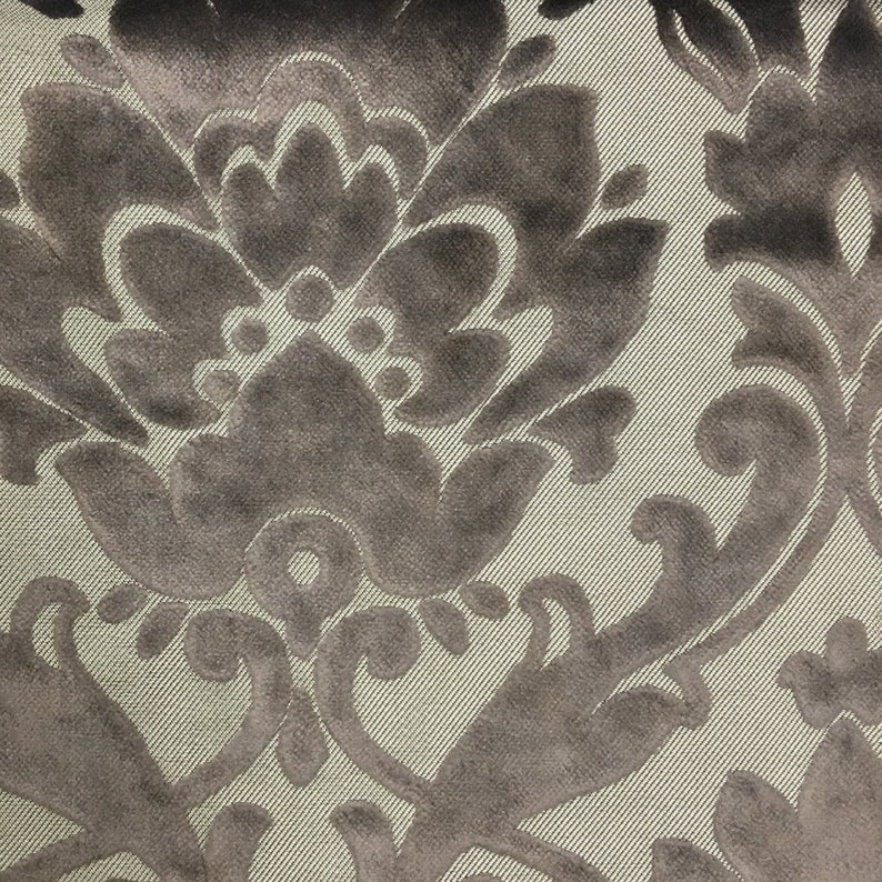 Pu&ograve; includere: Un tessuto con un motivo damascato in velluto grigio scuro su uno sfondo beige chiaro con una sottile trama a coste diagonali. Il design in velluto &egrave; composto da grandi motivi floreali e foglie simmetriche.