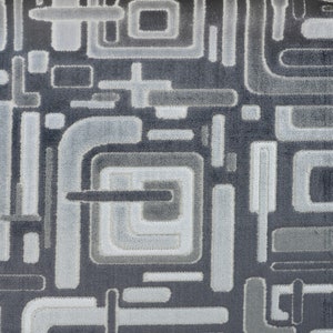 Peut inclure: Gros plan sur un tissu gris avec un motif géométrique blanc. Le motif est composé de carrés, de rectangles et de cercles.