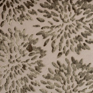 May include: Close-up of a fabric with a textured, embossed pattern. The fabric has a light beige background with a dark brown floral design.