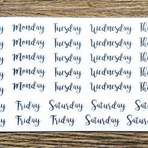 May include: A sheet of white stickers with black text. The stickers feature the days of the week, including Sunday, Monday, Tuesday, Wednesday, Thursday, Friday, and Saturday. Each day of the week is repeated five times on the sheet.