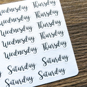 May include: A sheet of clear stickers with black lettering. The stickers feature the words "Wednesday", "Thursday", and "Saturday" repeated multiple times.