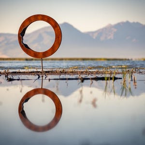 Eroded Zero: Abstract geometric metal sculpture.