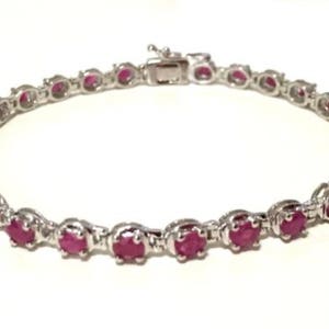 May include: A silver bracelet with a row of pink oval-shaped gemstones.