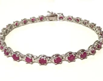 May include: A silver bracelet with a row of pink oval-shaped gemstones.