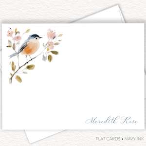 May include: White flat cards with a watercolor illustration of a bird perched on a branch with pink flowers. The name "Meredith Rose" is written in navy ink. The words "FLAT CARDS • NAVY INK" are at the bottom.