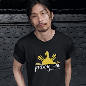 May include: Black t-shirt with a yellow sun and the text "pulang ina" in white. The sun has eight rays and is a stylized version of the Philippine sun.