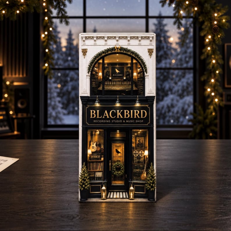 May include: A miniature Blackbird Recording Studio and Music Shop building model featuring a white upper facade with an arched window and a black storefront with gold lettering. The interior displays musical instruments and recording equipment.