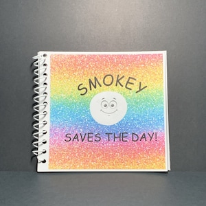 Puede incluir: Un cuaderno de espiral con una cubierta de purpurina arcoíris. La cubierta presenta una cara sonriente de dibujos animados con el texto "SMOKEY SAVES THE DAY!"