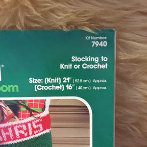 May include: A green and red Christmas stocking with the word "CHRIS" knitted in white on the front. The stocking is 21 inches long when knitted and 16 inches long when crocheted. The kit number is 7940.