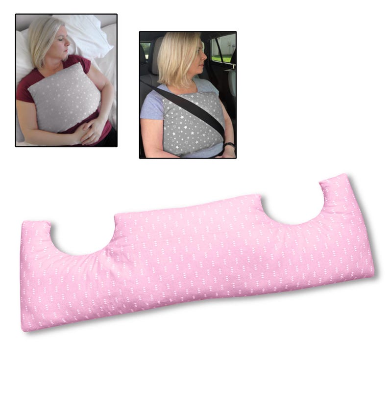 May include: A pink pillow with a white dotted pattern and curved cutouts. The pillow is shown in use in a car and in bed. The pillow is designed to provide support and comfort.