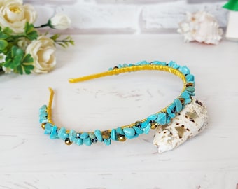 May include: A yellow headband adorned with small, irregular turquoise-coloured stone chips and tiny metallic gold beads. The headband features a wire-wrapped design that secures the stones and beads along the entire length of the band.