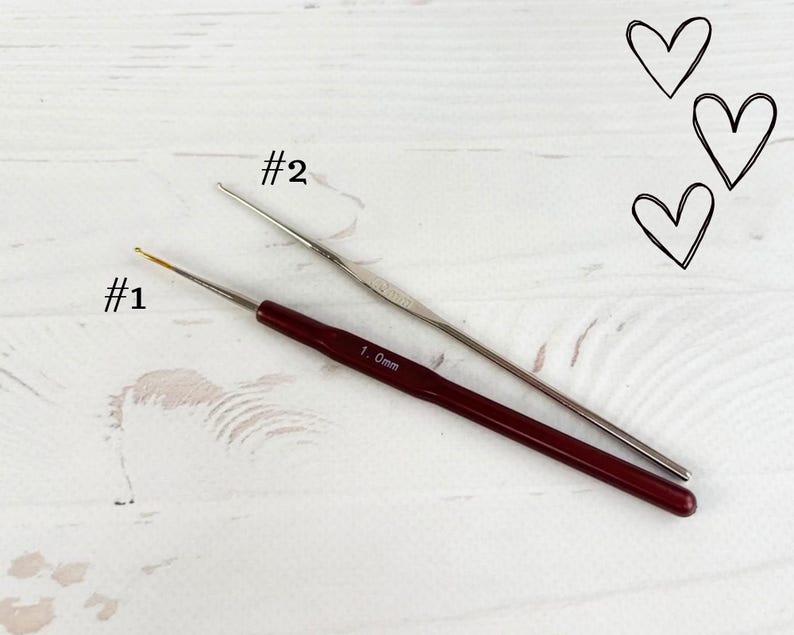 May include: Two crochet hooks, one silver and one red, labelled #1 and #2. The red hook is labelled 1.0mm.