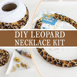 May include: A white ceramic mug with a black handle and the text "But First, Coffee" in a bold, black font. The mug is set against a blurred background. The mug appears to be approximately 10 cm tall.