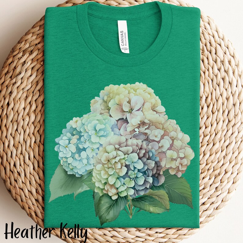 May include: A green t-shirt with a watercolor illustration of a bouquet of blue, white, and purple hydrangeas.