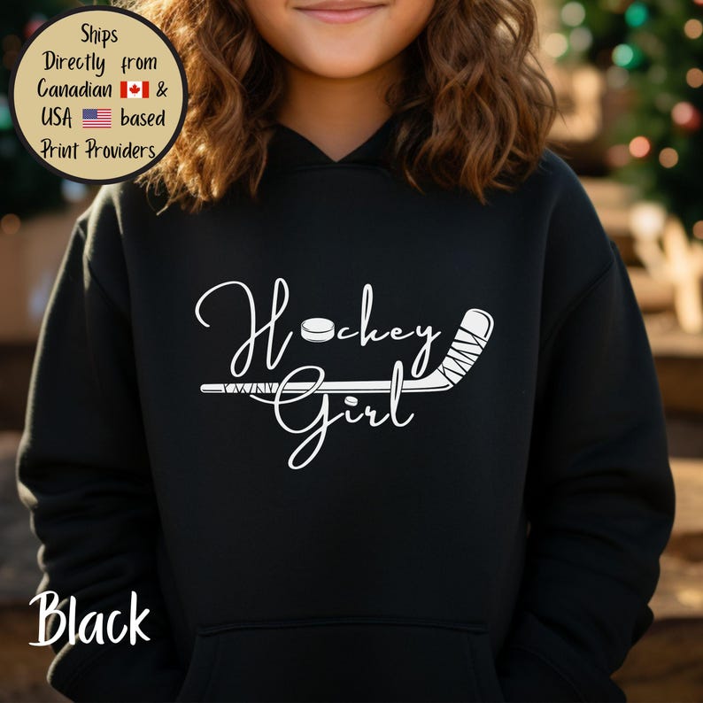 May include: Black hoodie with the words "Hockey Girl" in white script, along with a hockey puck and stick graphic. The hoodie has a front pocket and a hood. The word "Black" is printed at the bottom left.