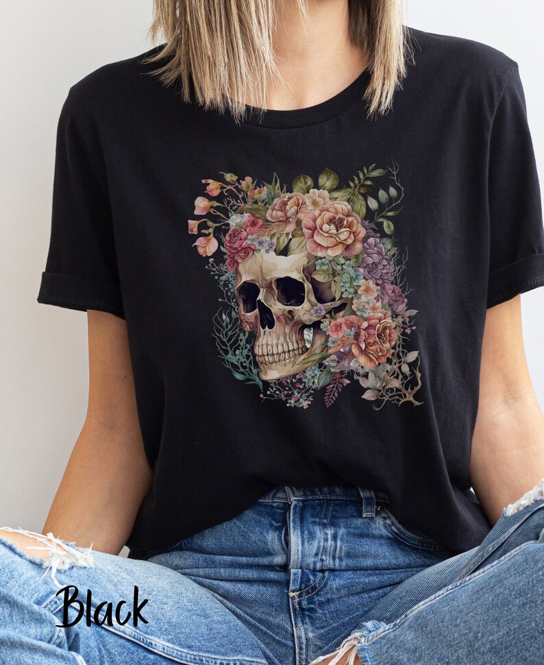 May include: Black t-shirt with a floral skull design. The skull is surrounded by pink, purple, and blue flowers.