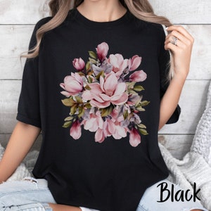 Peut inclure: T-shirt noir avec un imprim&eacute; floral rose de fleurs de magnolia.