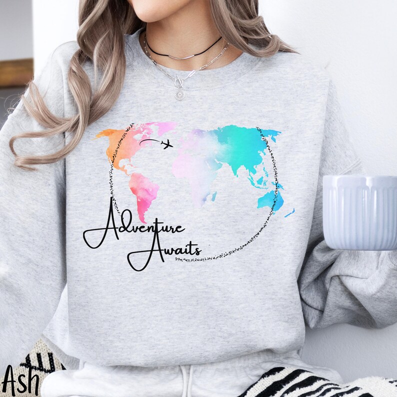 May include: A gray sweatshirt with a watercolor world map design and the text "Adventure Awaits".
