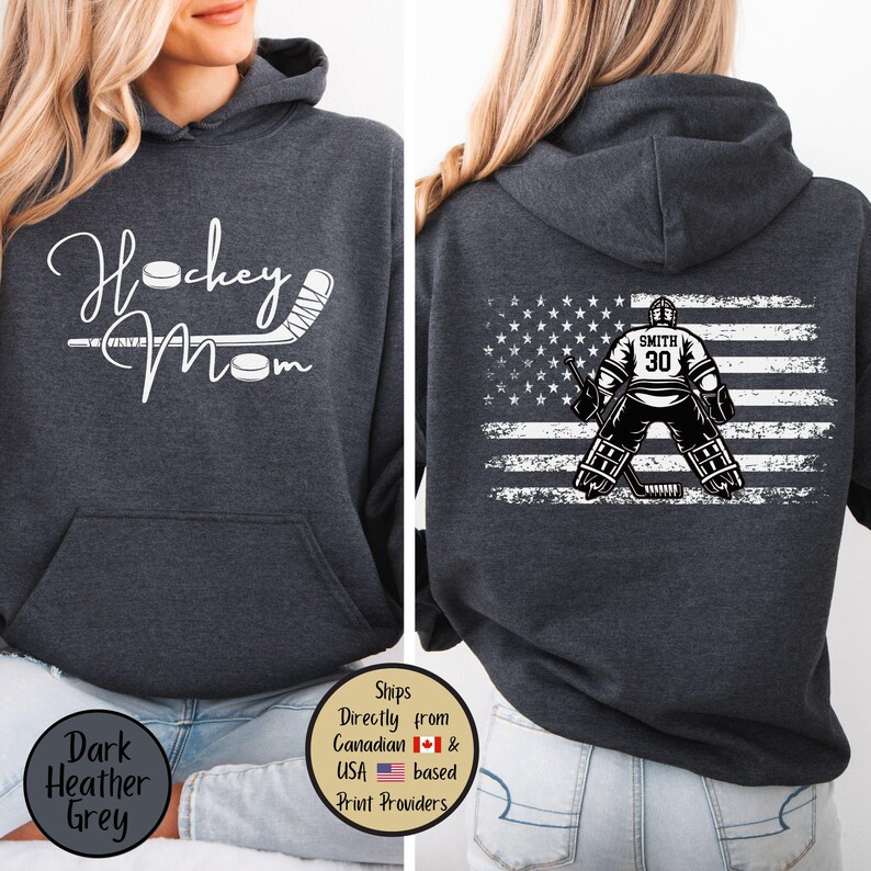May include: Dark heather grey hoodie with the text "Hockey Mom" and a hockey stick and puck graphic. The back features an American flag design with a hockey goalie and the name "Smith" and the number "30".