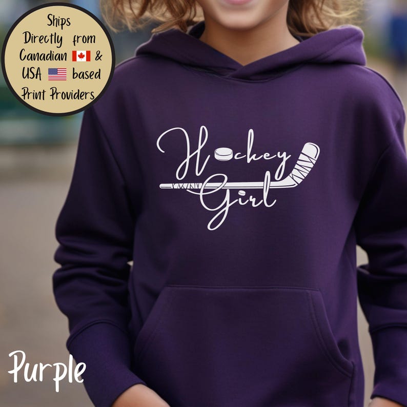 May include: A purple hoodie with a front pocket. The hoodie features the white text "Hockey Girl" with a hockey stick and puck graphic. The word "Purple" is at the bottom left.