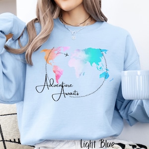 May include: Light blue sweatshirt with a watercolor world map design and the text "Adventure Awaits".