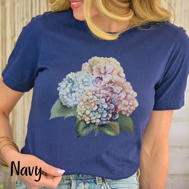 May include: A navy blue t-shirt with a floral print of hydrangeas in shades of pink, blue, and white.