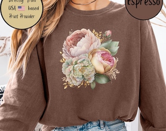 May include: Espresso-colored sweatshirt featuring a floral design with pink, white, and green peonies. The sweatshirt has a crew neck and long sleeves. The text "Espresso" is in a brown circle. The image also includes text that reads "Ships Directly from USA based Print Provider."