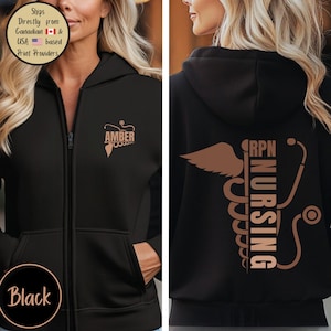 May include: Black zip-up hoodie with a hood. The front features the name "AMBER" and a medical symbol in a copper colour. The back displays a copper-coloured design with the words "RPN NURSING" and a stethoscope.