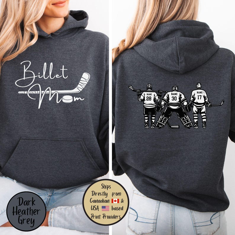 May include: Dark heather grey hoodie with a front graphic that says "Billet Mom" with a hockey stick and puck. The back features a hockey team graphic with player numbers and names. The hoodie has a hood and a front pocket.