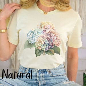 May include: A white t-shirt with a floral print of pastel blue, pink, and purple hydrangeas.