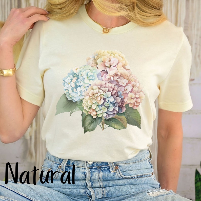 May include: A white t-shirt with a floral print of pastel blue, pink, and purple hydrangeas.