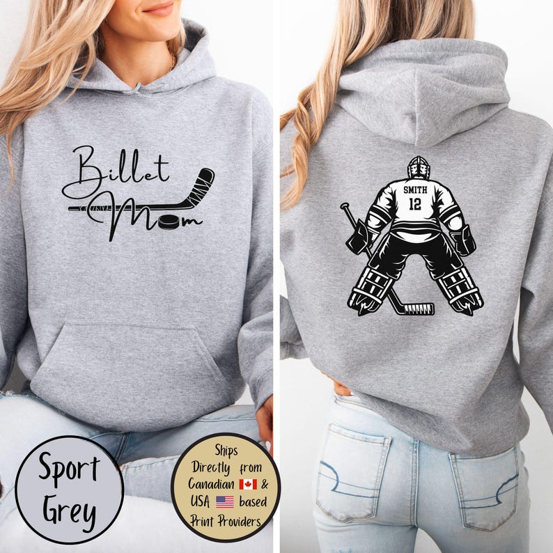 May include: A light grey hoodie with the words "Billet Mom" and a hockey stick graphic on the front. The back features a hockey goalie illustration with the name "Smith" and the number "12". The hoodie is labeled "Sport Grey".
