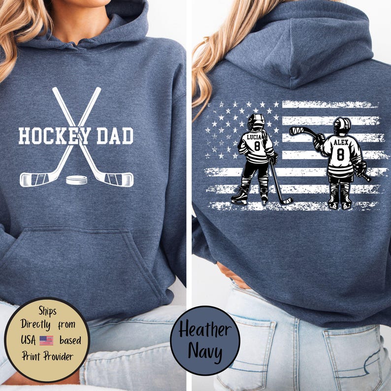 Puede incluir: Sudadera con capucha azul marino jaspeado con la inscripci&oacute;n "HOCKEY DAD" y palos de hockey cruzados y un disco en la parte delantera. La parte trasera presenta dos jugadores de hockey frente a un dise&ntilde;o de bandera americana. Los nombres "LUCIA" y "ALEX" est&aacute;n encima del n&uacute;mero 8.