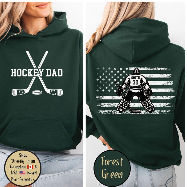 Puede incluir: Sudadera con capucha verde bosque con "HOCKEY DAD" y un gr&aacute;fico de palos de hockey en la parte delantera. La parte trasera presenta un dise&ntilde;o de portero de hockey con un fondo de bandera estadounidense.