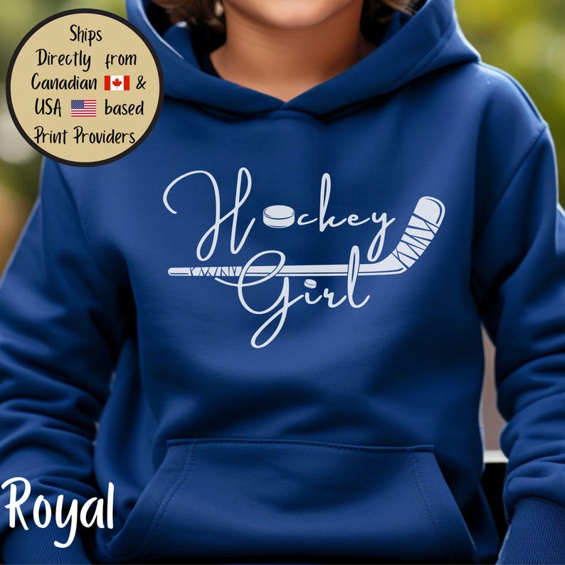 May include: Royal blue hoodie with a white Hockey Girl graphic. The design includes a hockey puck and stick. The hoodie has a front pocket and a hood. The text "Royal" is at the bottom of the image.