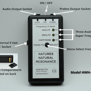 May include: Black rectangular device with a white label displaying text about frequency and resonance. Features include an audio output socket, probes output socket, and a menu select button. The device has a battery compartment and is labeled "Natures Natural Resonance."