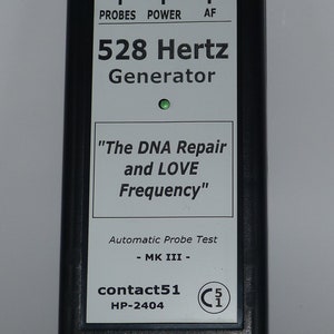 Könnte beinhalten: Ein schwarz-weißes Gerät mit einem grünen Licht, beschriftet mit "528 Hertz Generator" und "The DNA Repair and LOVE Frequency". Es trägt auch den Text "Automatic Probe Test - MK III - contact51 HP-2404" und ein CE-Zeichen.