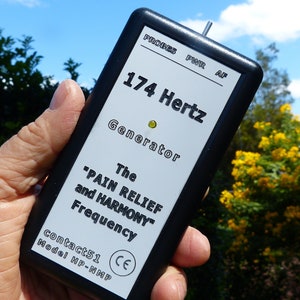 Könnte beinhalten: Ein schwarzes rechteckiges Gerät mit dem Text "174 Hertz Generator" und "PAIN RELIEF and HARMONY Frequency" auf weißem Hintergrund. Das Gerät hat eine kleine Antenne und ein grünes Licht. Die Modellnummer ist HP-NMP.
