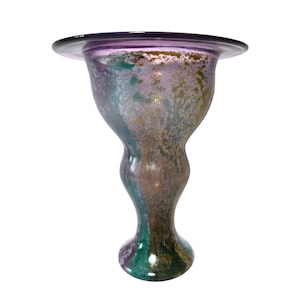 May include: A glass vase with a wide, flat rim and a curved, hourglass-shaped body. The surface features a mottled, iridescent finish with blended hues of purple, teal, and metallic gold, creating a textured appearance across the entire piece.